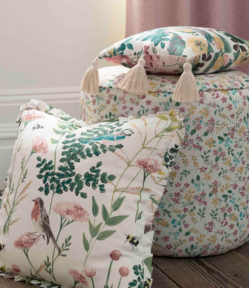 Cojín confeccionado con tela de algodón grueso estampado de ramos de flores, pequeñas aves y libélulas